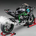 Realistic black toy motorcycle model with green frame, smoke effect, displayed on red stands, Tafeen Toys